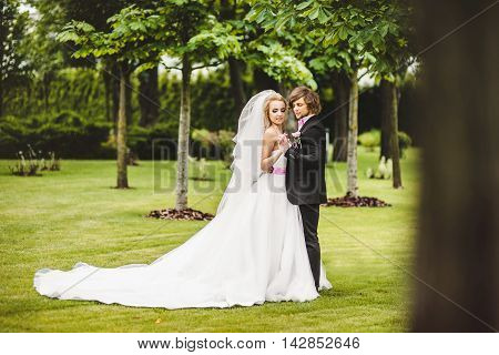 Elegant bride and groom posing together outdoors on a wedding day