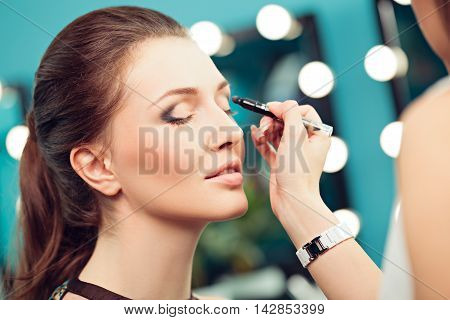 Make-up artist and model at work close up of model