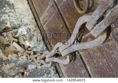 Old rusty chain and massive wrought iron doors