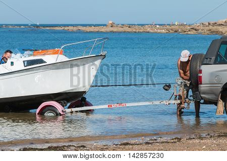 Men Getting Boats Out Of Water With Car On The Beach