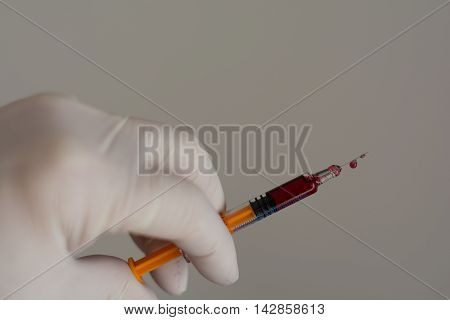 Person with latex glove pushes syringe - closeup