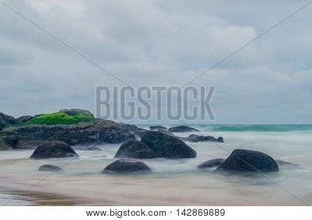 moss on the giant rock with motion of sea