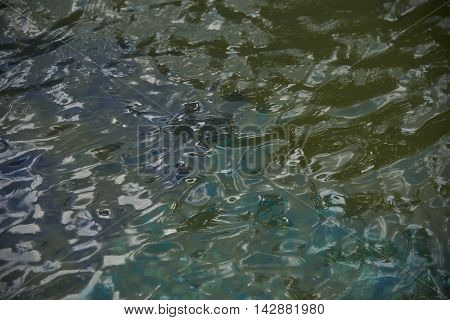 Reflections in the water with small waves. Abstraction texture background