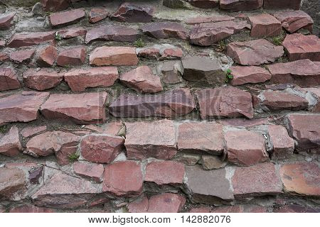 Stairs of granite rubble irregularly shaped red. Texture background