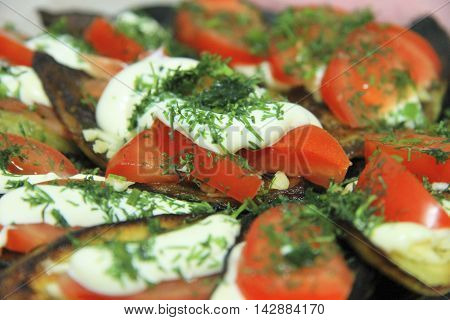 Fried eggplants and fresh tomato with souce and herbs