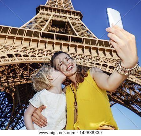 Mother And Daughter Tourists Taking Selfie Near Eiffel Tower