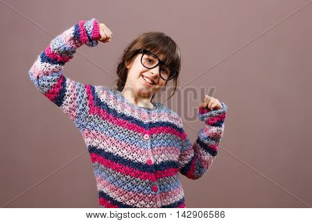 Cute little nerdy girl is showing how self-confident she is.