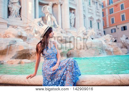 Young beautiful girl near fountain Fontana di Trevi with city map