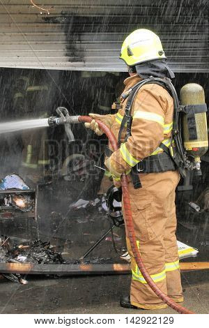 Melbourne Victoria Australia - 2011 July 10: Fire fighter spraying water on a garage on fire in an residential area of Glen Waverley in Melbourne east.