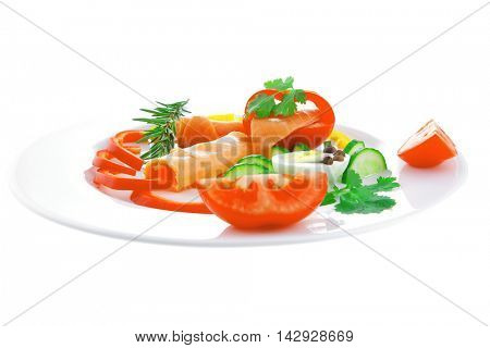 smoked salmon slices with vegetabls over white plate