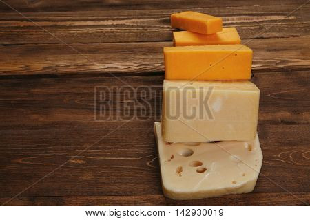 various types of fresh raw aged delicatessen cheese on wooden table cheddar edam swiss