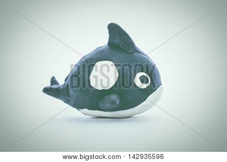 Creative clay model. Whale from children bright play dough on white background. Play dough animal. Studio shot. Vintage tone effect.