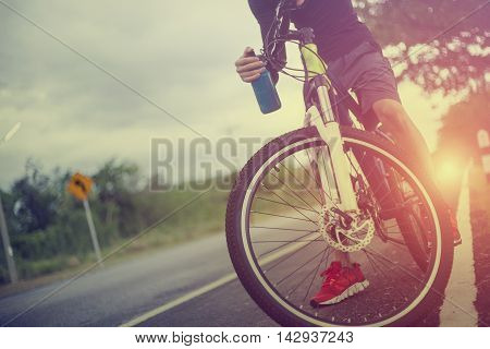 Man Riding A Bicycle In A Road Outdoors At Sunsetvintage Color Film Grain