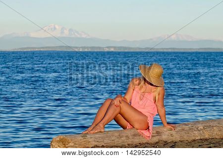 Young woman sitting on beach by sea. Centennial Beach in Boundary Bay Regional Park Tsawwassen British Columbia Canada