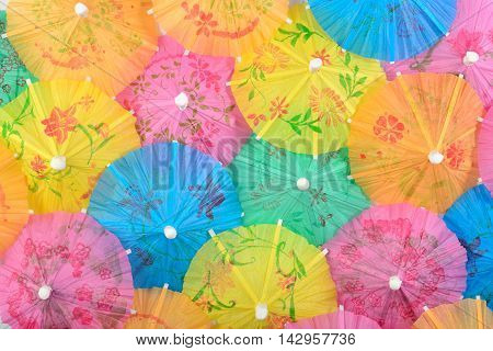 Colorful paper cocktail umbrella close-up as background