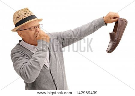Disgusted old man holding a smelly shoe isolated on white background