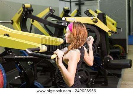 Sport, Fitness, Lifestyle And People Concept - Close Up Of Young Woman Flexing Muscles On Cable Gym 