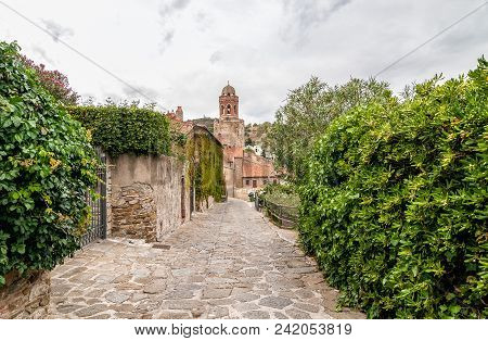 The Street With San Giovanni Battista Church In Background In Castiglione Della Pescaia, Tuscany, It
