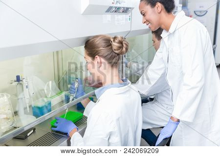 Group of scientists in research laboratory working under splashback