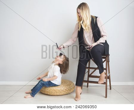 Mother And Daughter Doing Make Up Oto Each Other. Family Fun Concept