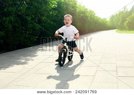Little Boy On A Bicycle. Caught In Motion, On A Driveway. Preschool Child's First Day On The Bike. T