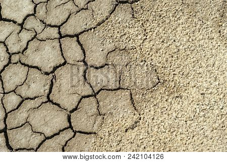 Background - Cracked Dry Sun-dried Clay Crust In A Waterless Desert Half Sanded With Sand