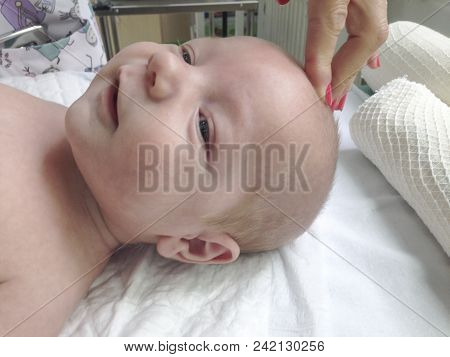 Pediatrician Examining The Fontanelle Of Smiling 3 Months Baby Boy