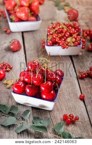 Fresh Summer Berries - Strawberry, Cherry And Red Current In Ceramic Bowls On The Rustic Wooden Tabl