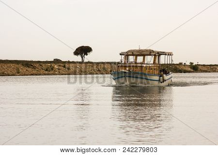 An Old Fishing Boat Sails Along The Canal