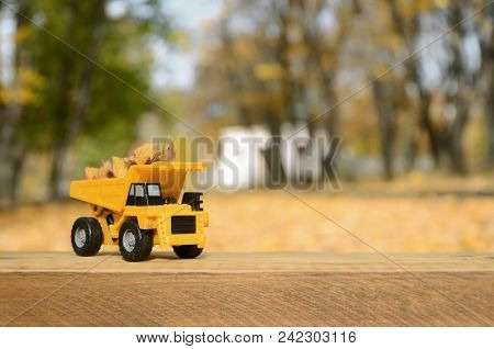 The Concept Of Seasonal Harvesting Of Autumn Fallen Leaves Is Depicted In The Form Of A Toy Yellow T