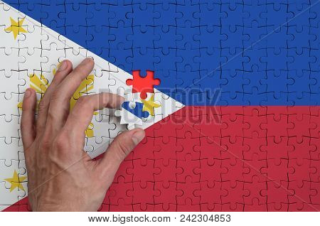 Philippines Flag  Is Depicted On A Puzzle, Which The Man's Hand Completes To Fold