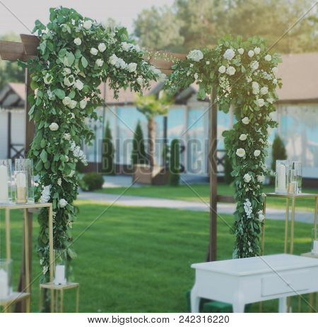Rustic Wedding Ceremony Arch On The Open Area With Greem Grass.