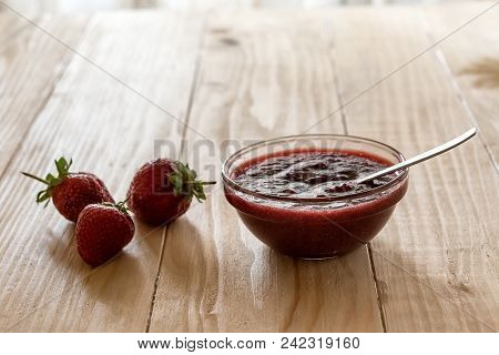 Homemade Strawberry Jam In A A Glass Bowl With Fresh Ripe Strawberries On A Wooden Table