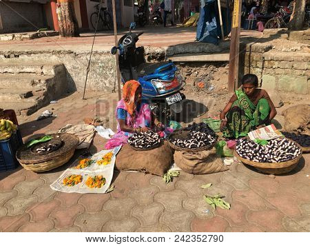 MANDLA, MADHYA PRADESH, INDIA - NOVEMBER 250, 2015: Unidentified Indian women with colorful traditional garments selling their fresh produce at an informal street market 