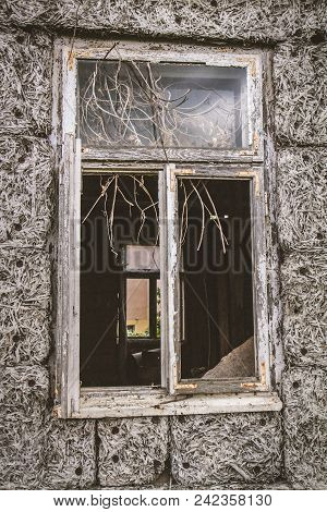 Broken Window Of An Abandoned House, With Naked Walls (no Plasterwork)
