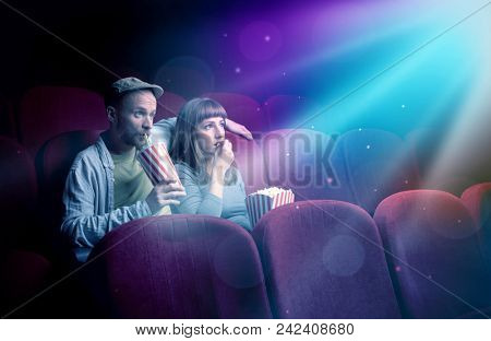 Teenager couple cuddling and watching the climax part of the movie