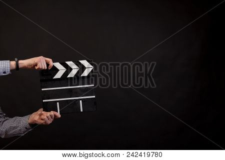 Сlapperboar In The Hands On Black Isolated Background
