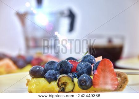 Piece Of Crostata With Berries And Fruits, On Behind Background Coffe Maker And A Cup Of Espresso
