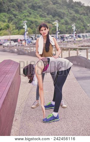 Sports Concept. Beautiful Girl Is Exercising On The Beach With Warm Up. Beautiful Girl Is Happy To E