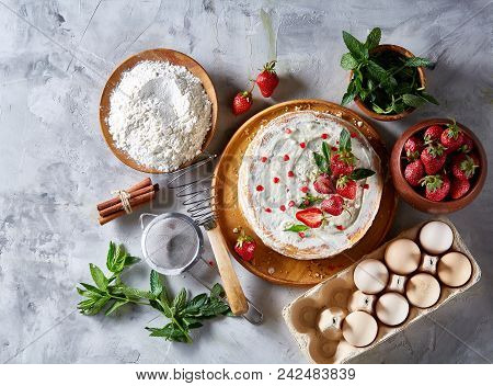 Strawberry Tart Covered With Whipped Sour Cream Surrounded By Organic Ingredients Over White Backgro