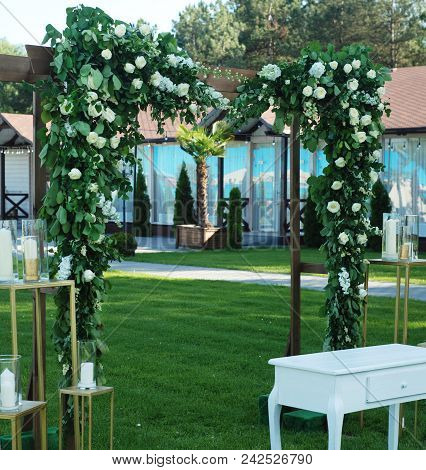 Rustic Wedding Ceremony Arch On The Open Area With Greem Grass.