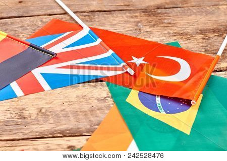 Different Country Flags On Table. Close Up, Flags On Wood.