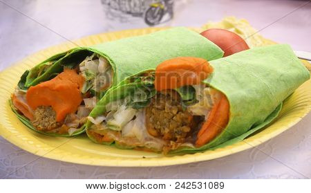 Falafel With Vegetables Lavash Wrap Cup To Two Pieces On Plate Close Up Photo