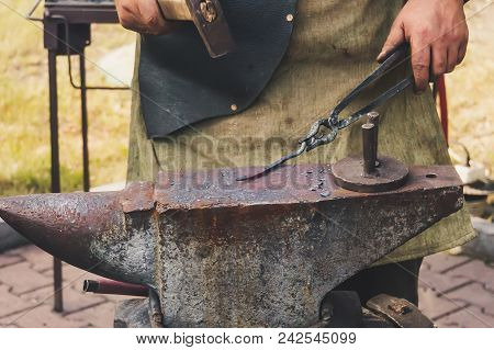 Detail Shot Of Hammer Forging Hot Iron At Anvil. Forging Hammer Of Metal Structures In The Open Air 
