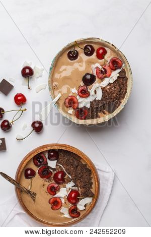 Chocolate - Cherry Smoothie Bowl With Coconut And Bananas On White Background, Top View. Healthy Veg