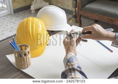 Construction Engineer Measuring With Vernier Caliper Business And Technology Concept Safety Helmet And Drawing Paper Elements Civil And Drawing Sketch Theme Poster Id 242578123