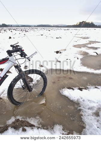 Bike Drowned In Muddy Pool Within Winter Trip. Broken Pieces Of Ice Around Freeze Terain Tyre, Wide 