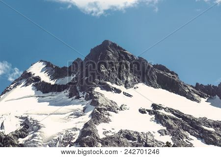 Mountain Landscape. The Top Of The Mountain On The Background Of Blue Sky. The Snowy Peak On The Bac