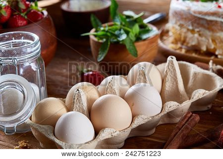 Top View Raw Ingredients For Cooking Strawberry Pie Or Cake On Wooden Table: Eggs, Sugar And Strawbe