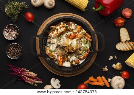 Chicken Stew With Vegetables Served In Cast Iron Pan On Black Background, Framed With Various Cookin